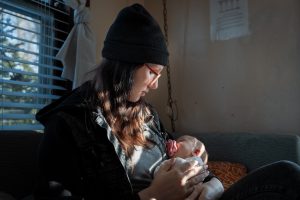 A woman holds her child in a bedroom