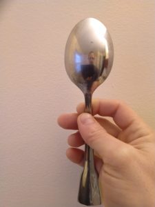 Dr. Toggerson in the back of a spoon. His image is behind the spoon and definitely smaller than he is!