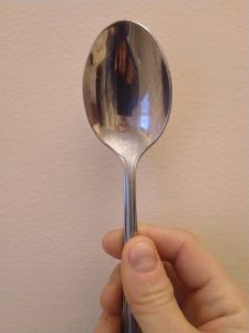 Dr. Toggerson's reflection on the inside of a spoon. Again, the image is smaller than the object. This time, the image is also inverted. Finally, if you look closely, the image appears to hover in front of the spoon!